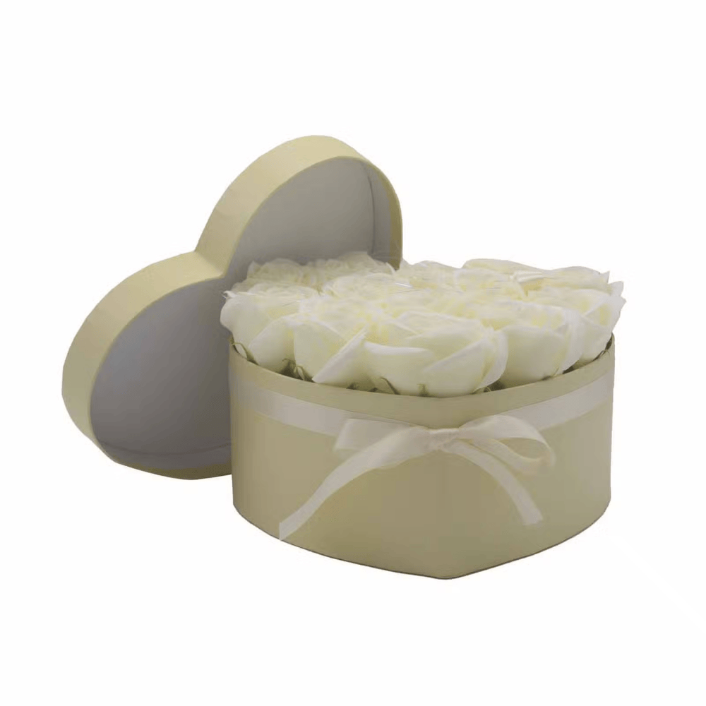 Heart-shaped box filled with white soap roses on a white background