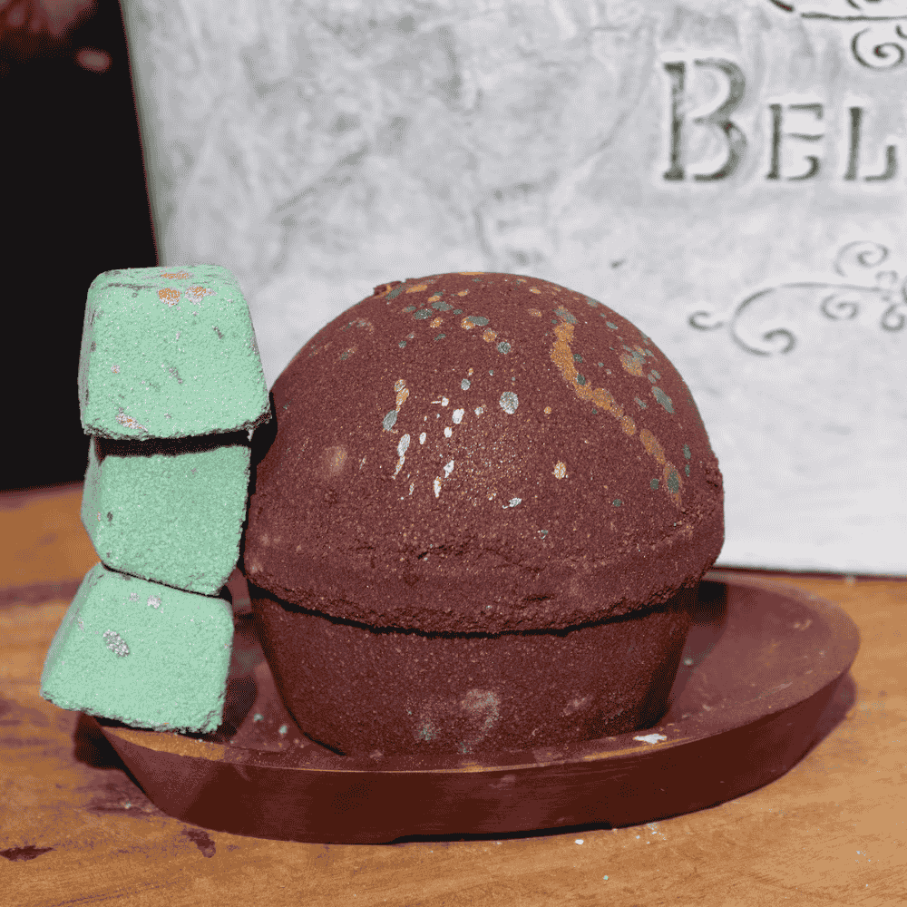 Brown bath bomb with green scrubber on a wooden surface