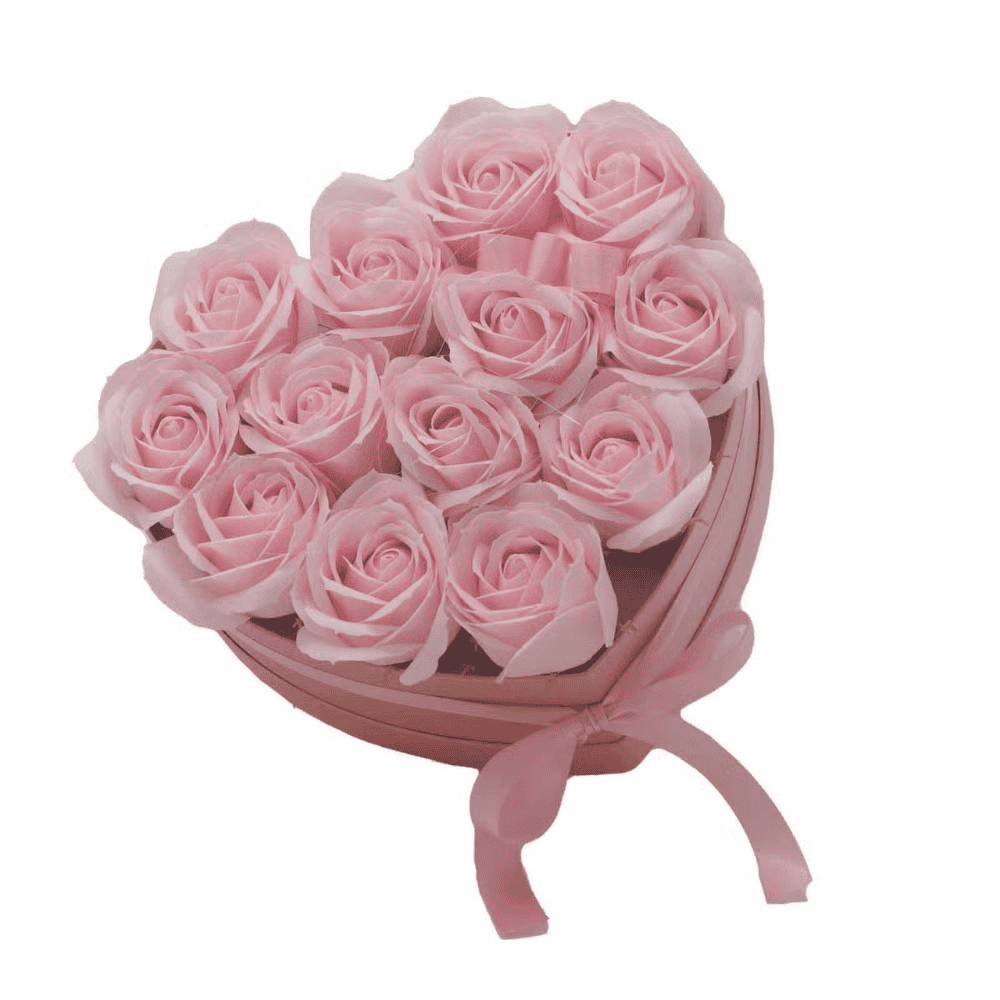 Heart-shaped box filled with pink roses on a white background up view