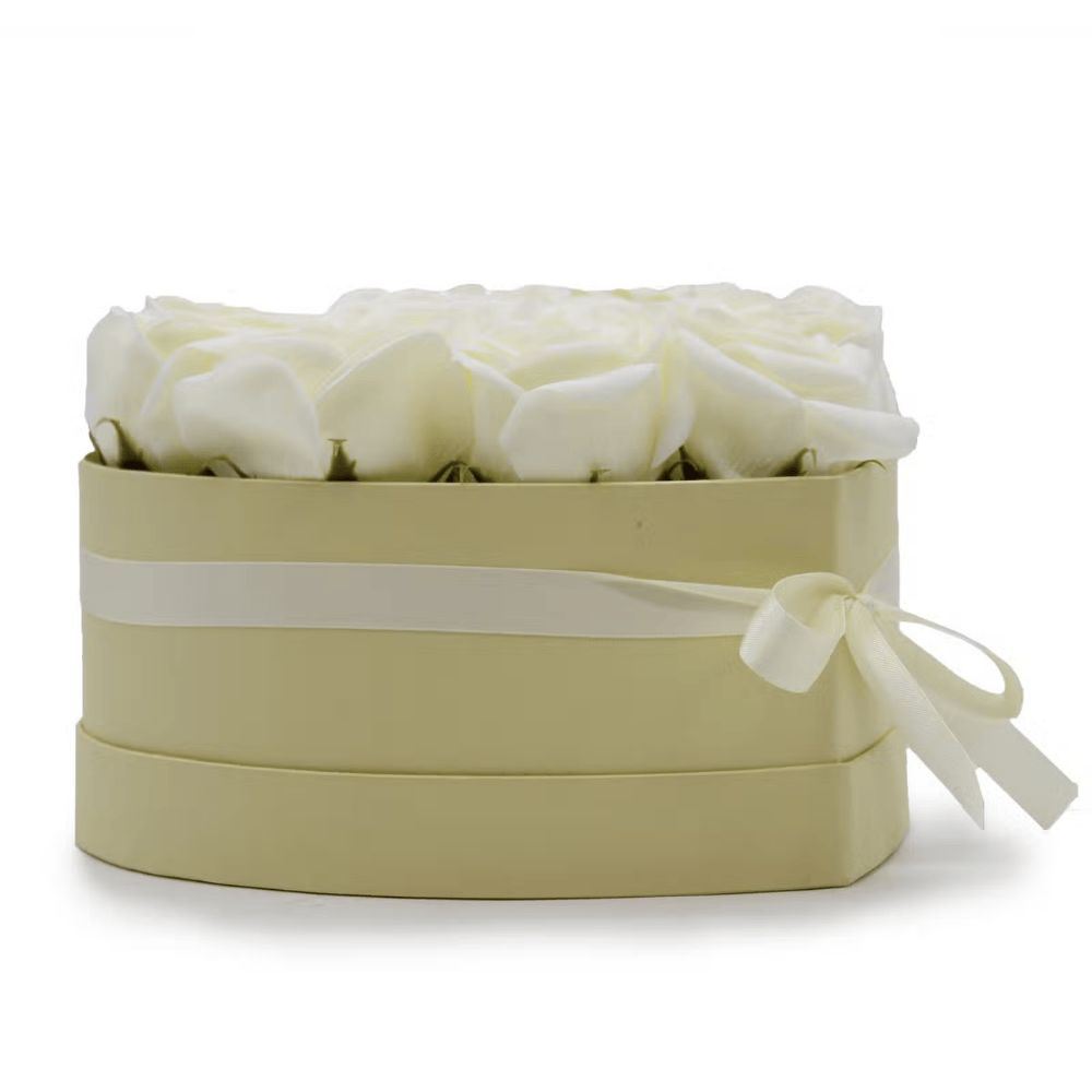 Heart-shaped box with white soap roses and a ribbon on a white background