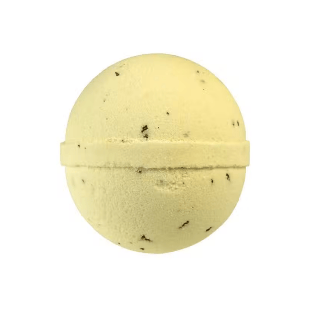 Yellow bath bomb with specks on a white background