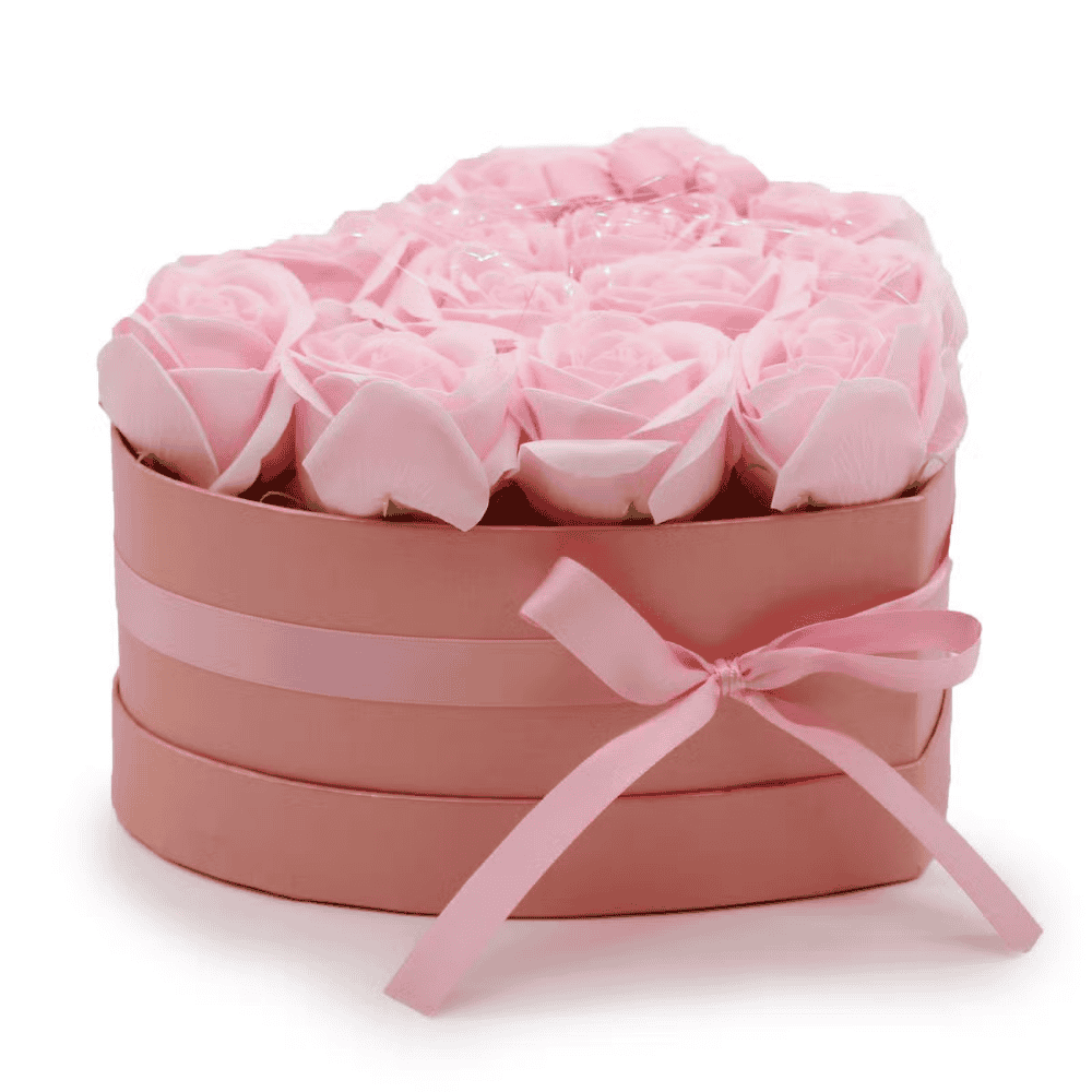 Heart-shaped box with bow filled with pink soap roses on a white background