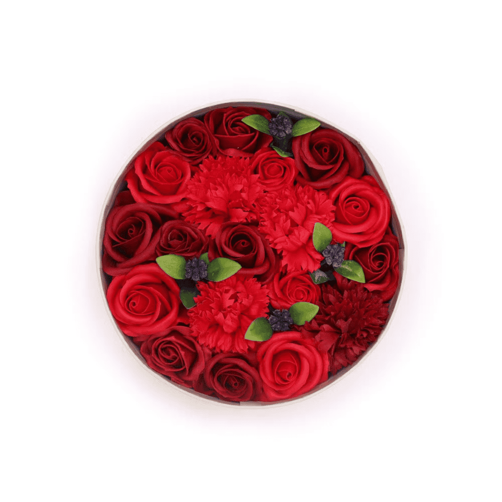 Round arrangement of red soap roses with green leaves on a white background