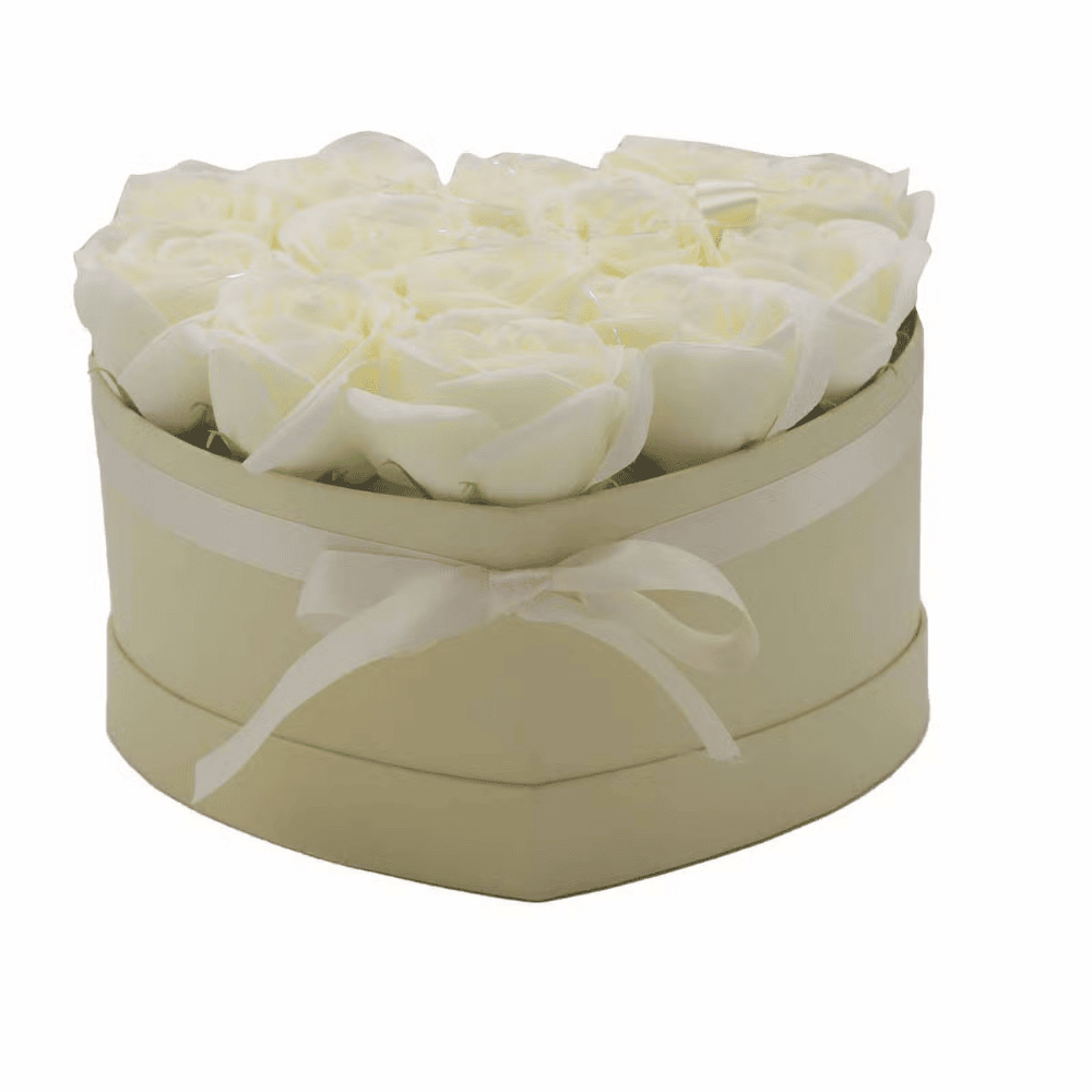 Heart-shaped box with white soap roses and a white ribbon on a white background