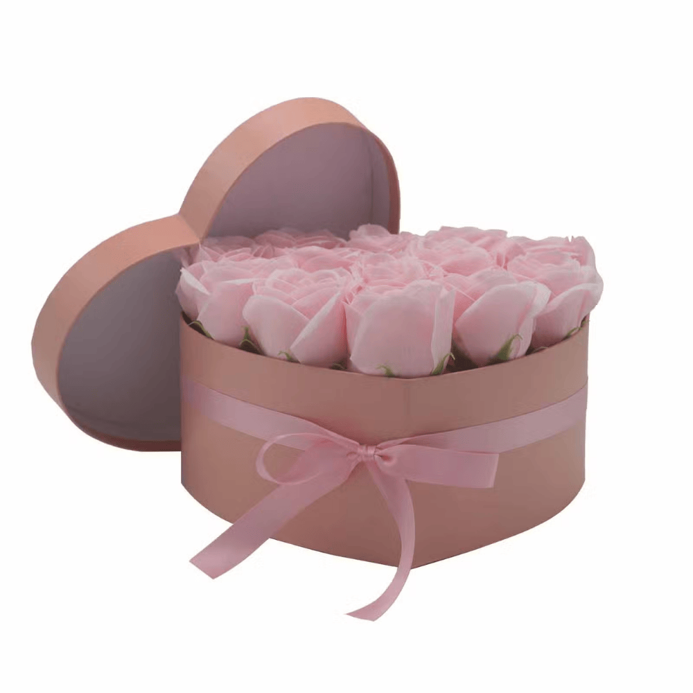 Heart-shaped box with pink soap roses and a pink ribbon on a white background