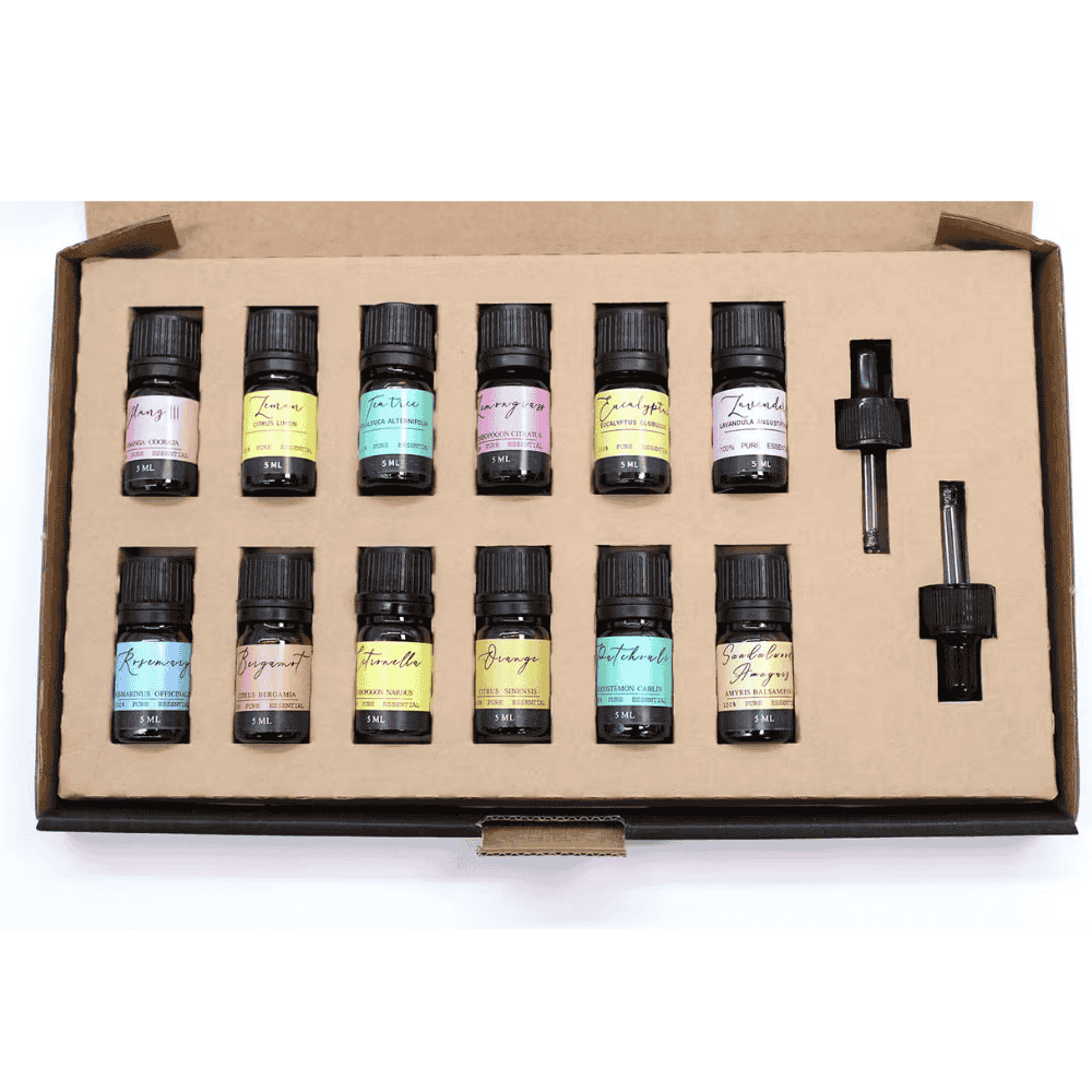Set of essential oil bottles in a cardboard box on a white background