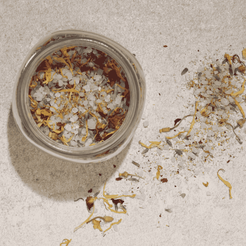 Jar of dried flowers and herbs on a textured surface