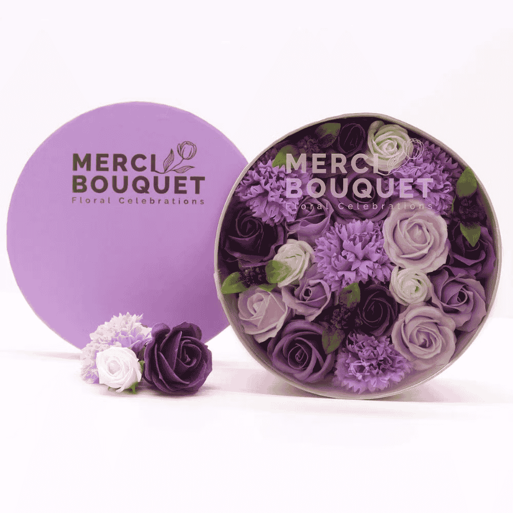 Round container with floral soap arrangement and purple lid featuring 'Merci Bouquet' branding on a white background.