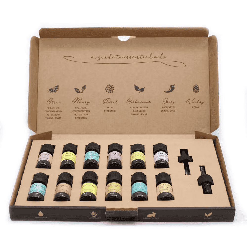 Set of essential oil bottles in a cardboard box with labels on a white background